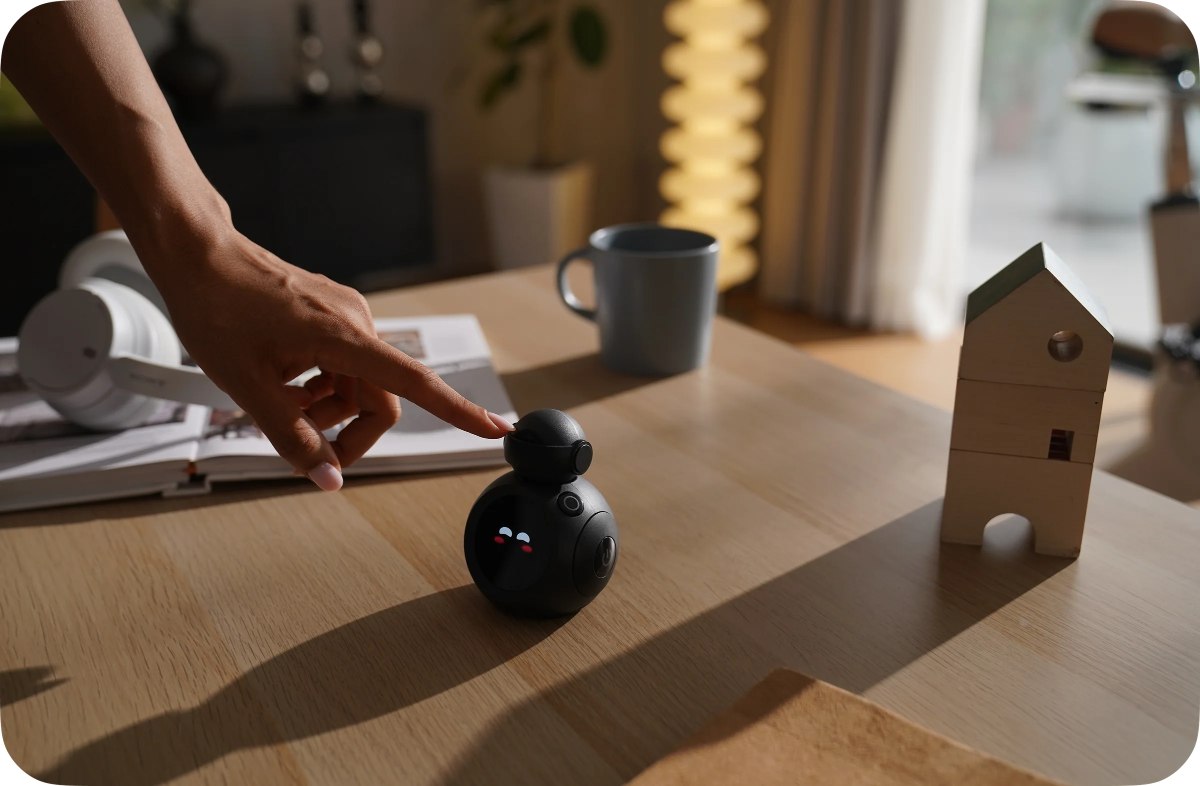 Hand interacting with ATOM on a desk