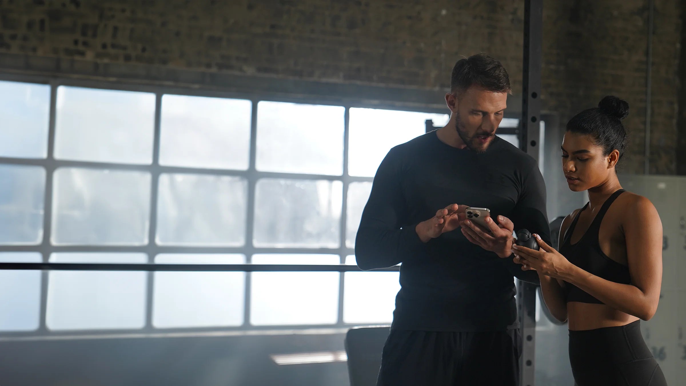 Two people reviewing training progress on a phone